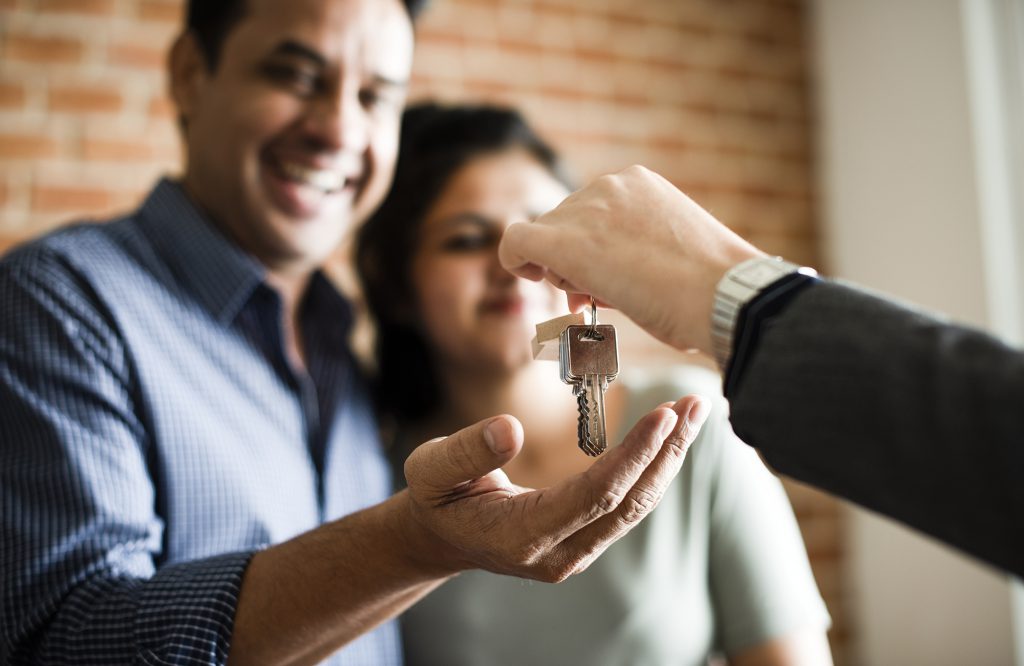 Image: man handing keys to smiling couple