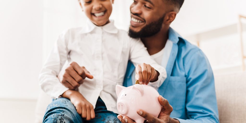 Image: Man and child put coin in piggy bank